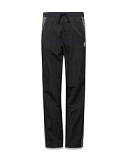 Kids Alder Nylon Colorblock Pant in black crinkled nylon with olive green side panels, featuring a relaxed fit and a small white Psycho Bunny skull logo on the right hip. (5)