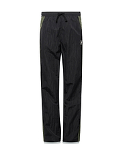 Kids Alder Nylon Colorblock Pant in black crinkled nylon with olive green side panels, featuring a relaxed fit and a small white Psycho Bunny skull logo on the right hip. (5)