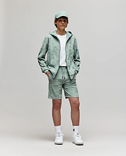 Teen | A young person stands against a plain background, wearing Psycho Bunny's KIDS KELVIN TOWEL TERRY SWEATSHORT (KB0900002) with a white tee, mint green cap and hoodie, and white sneakers, hands in pockets, looking at the camera.