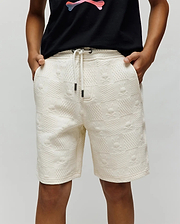 Kids Dustin Sweatshort in cream, featuring a relaxed fit and textured jacquard fabric with an all-over embossed checkerboard pattern of small Psycho Bunny skull logos. Dark drawstring tips.