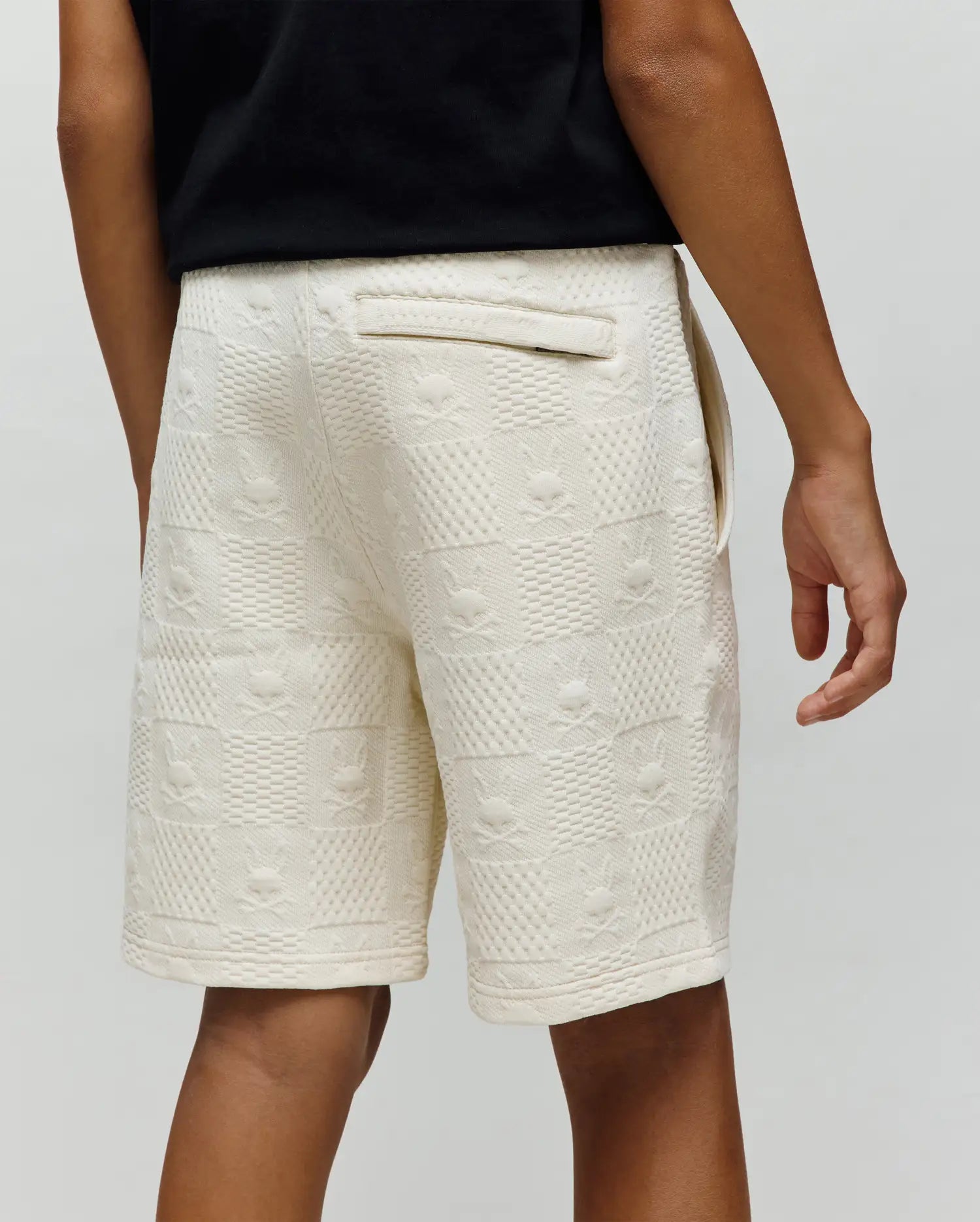 Kids Dustin Sweatshort in cream, featuring a relaxed fit and a textured jacquard knit with an all-over embossed checkerboard pattern of small Psycho Bunny skull logos.