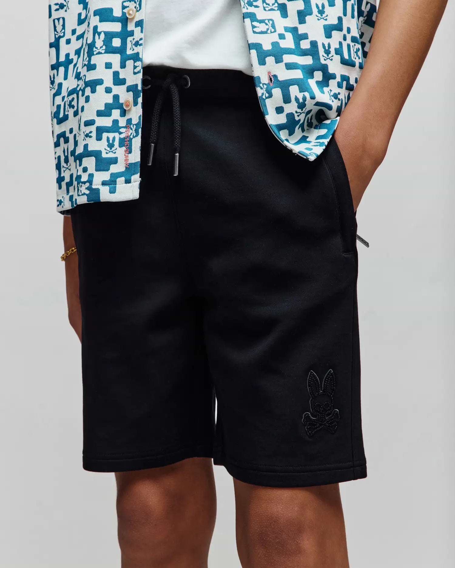 Kids Barry Modal Short in black, a relaxed fit, smooth modal blend fabric, featuring a drawstring waist with silver tips and a tonal embroidered Psycho Bunny skull logo on the left leg.