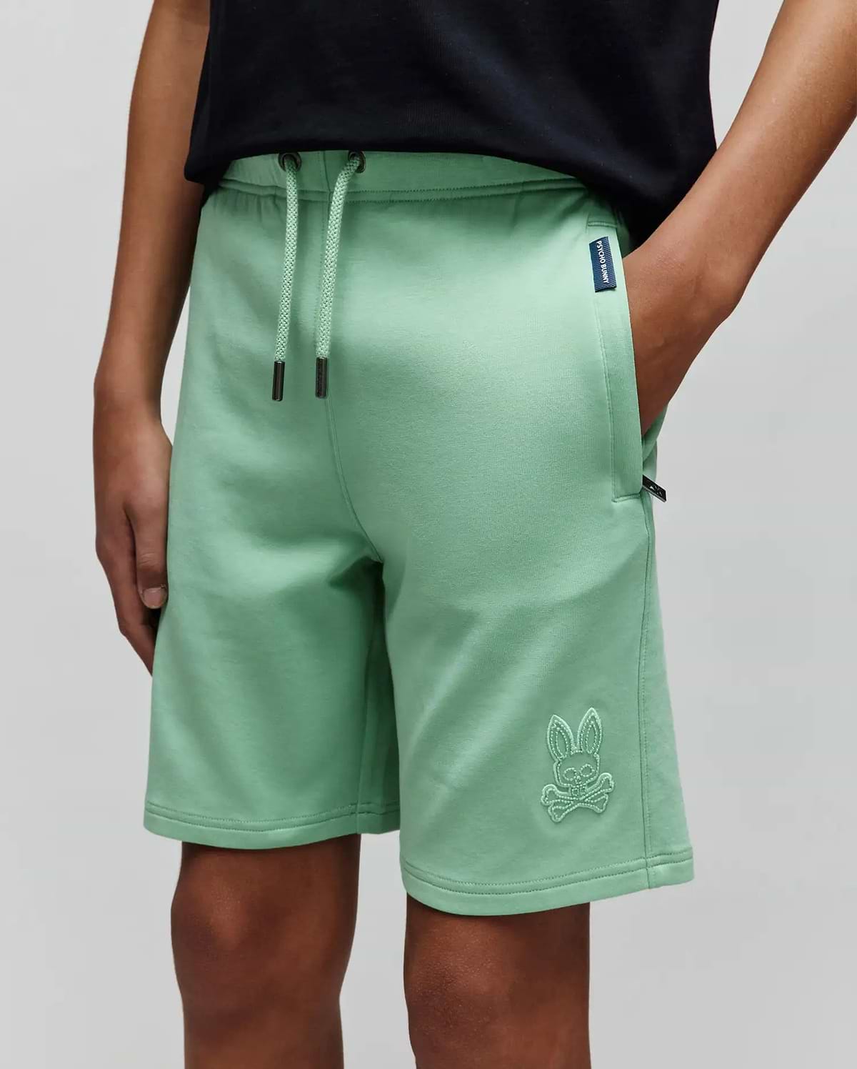 Kids Barry Modal Short in mint green, featuring a relaxed fit, soft modal fabric, drawstring waist, and a large embroidered Psycho Bunny skull logo on the left leg, plus a small navy brand tag. (2)