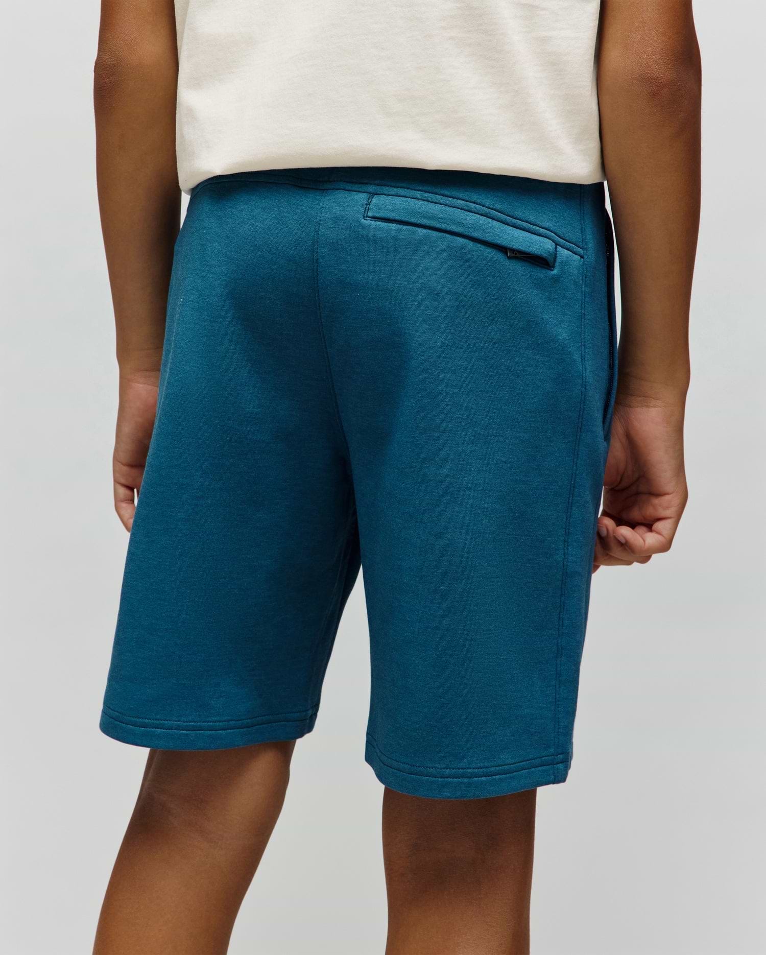 Kids Barry Modal Short in deep teal, featuring a relaxed fit, soft modal knit fabric, and a back welt pocket with a small black Psycho Bunny tag.
