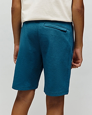 Kids Barry Modal Short in deep teal, featuring a relaxed fit, soft modal knit fabric, and a back welt pocket with a small black Psycho Bunny tag.