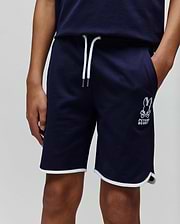 Kids Toby Short, navy relaxed fit jersey shorts featuring white drawstrings, white piping on the rounded hem, and an embroidered white Psycho Bunny skull logo on the left thigh.