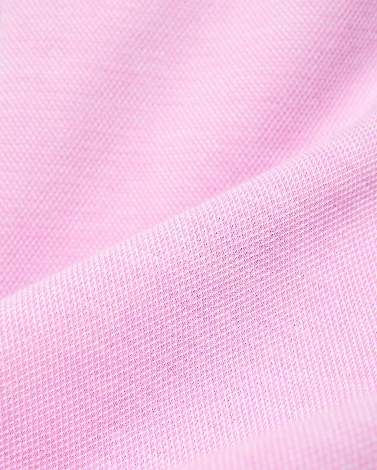 Psycho Bunny Kids Keith Short, a premium streetwear garment, features a vibrant pink pique knit fabric with a distinct textured weave, reflecting the brand's bold color aesthetic. (5)