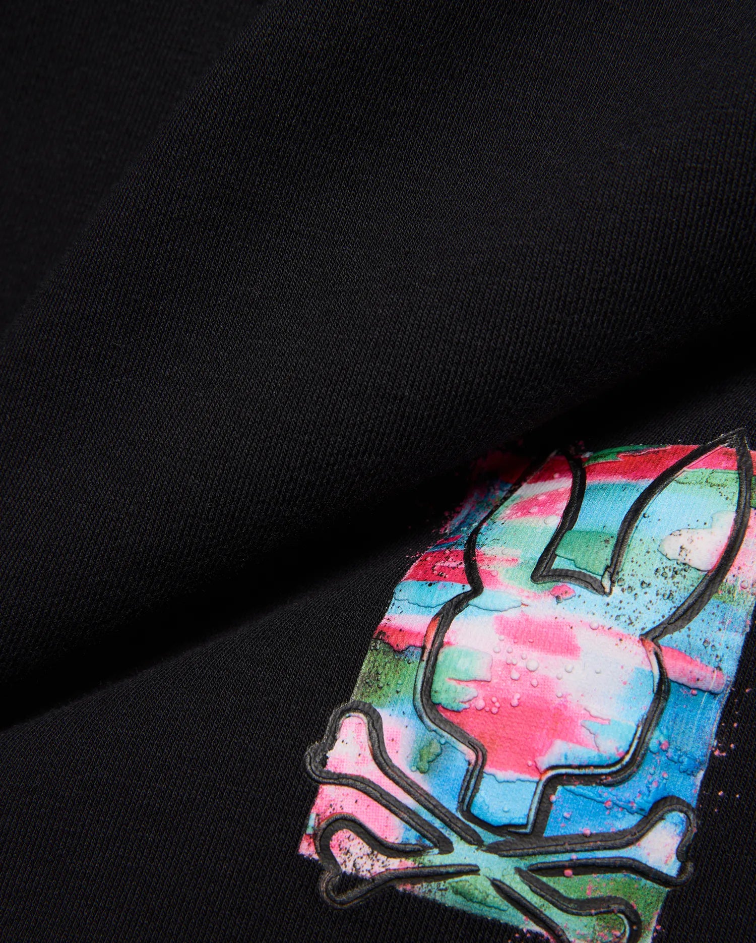 Kids Isaac Print Short in black jersey, featuring a large, vibrant Psycho Bunny skull logo with pink, blue, green, and white paint-splatter print and a raised black outline.