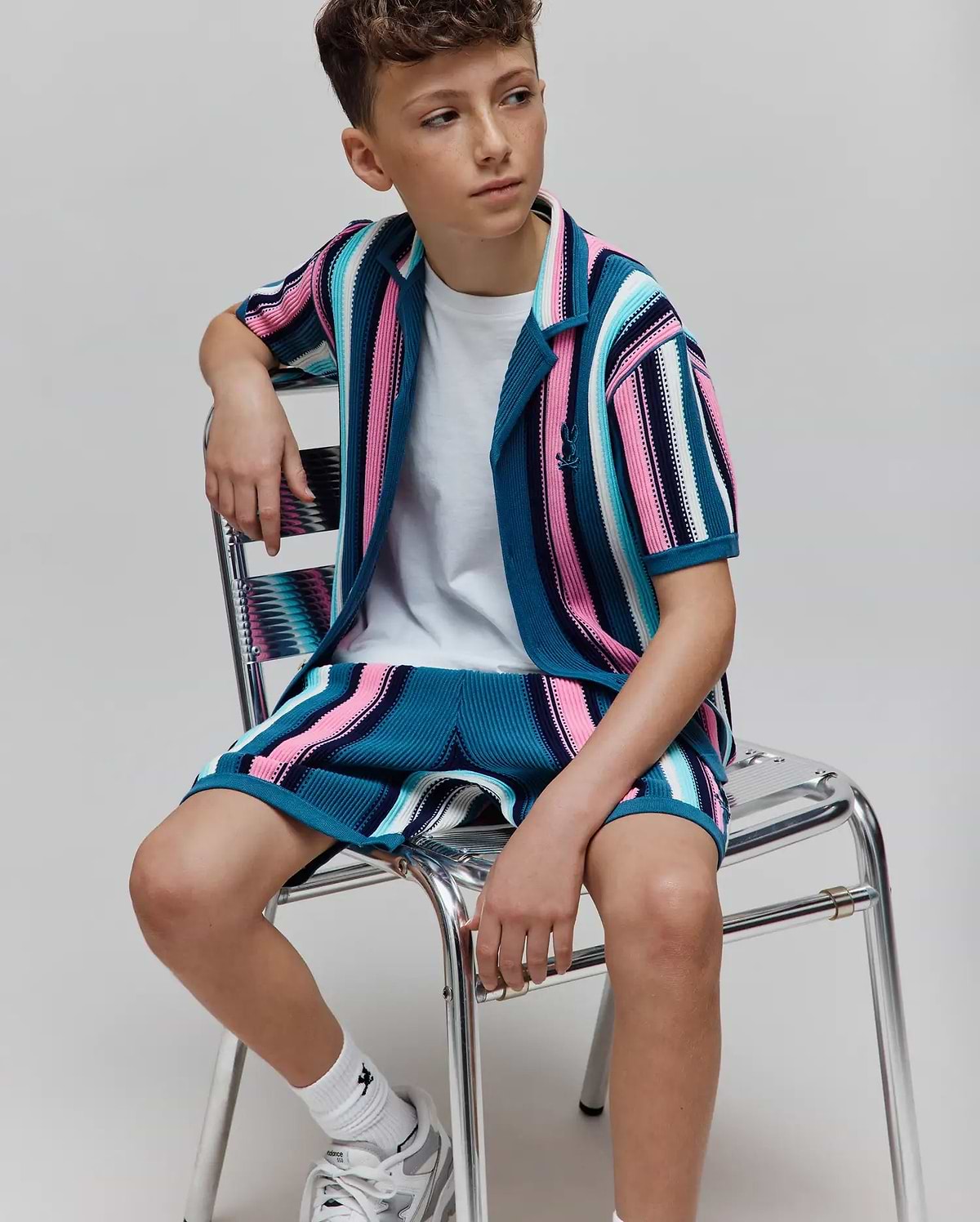 Kids Cliff Knit Short and matching short-sleeve shirt set featuring bold vertical stripes in teal, pink, white, and black, with a ribbed knit texture and small embroidered Psycho Bunny skull logo on the left chest. (3)