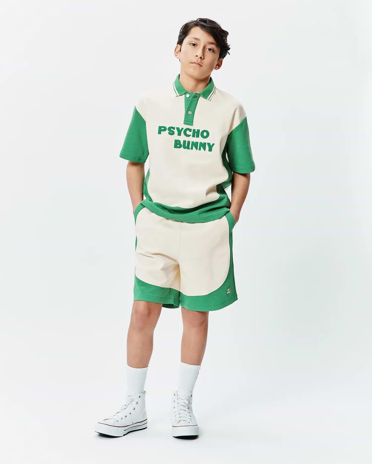 Premium Psycho Bunny cream and green color block polo shirt with bold chest text, paired with matching soft knit Kids Kelly Short featuring a subtle embroidered bunny skull logo.