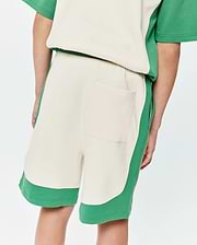 Kids Kelly Short, a relaxed fit, cream and green color-block design in soft french terry fabric, featuring curved green side panels, a green hem, and a single back patch pocket.