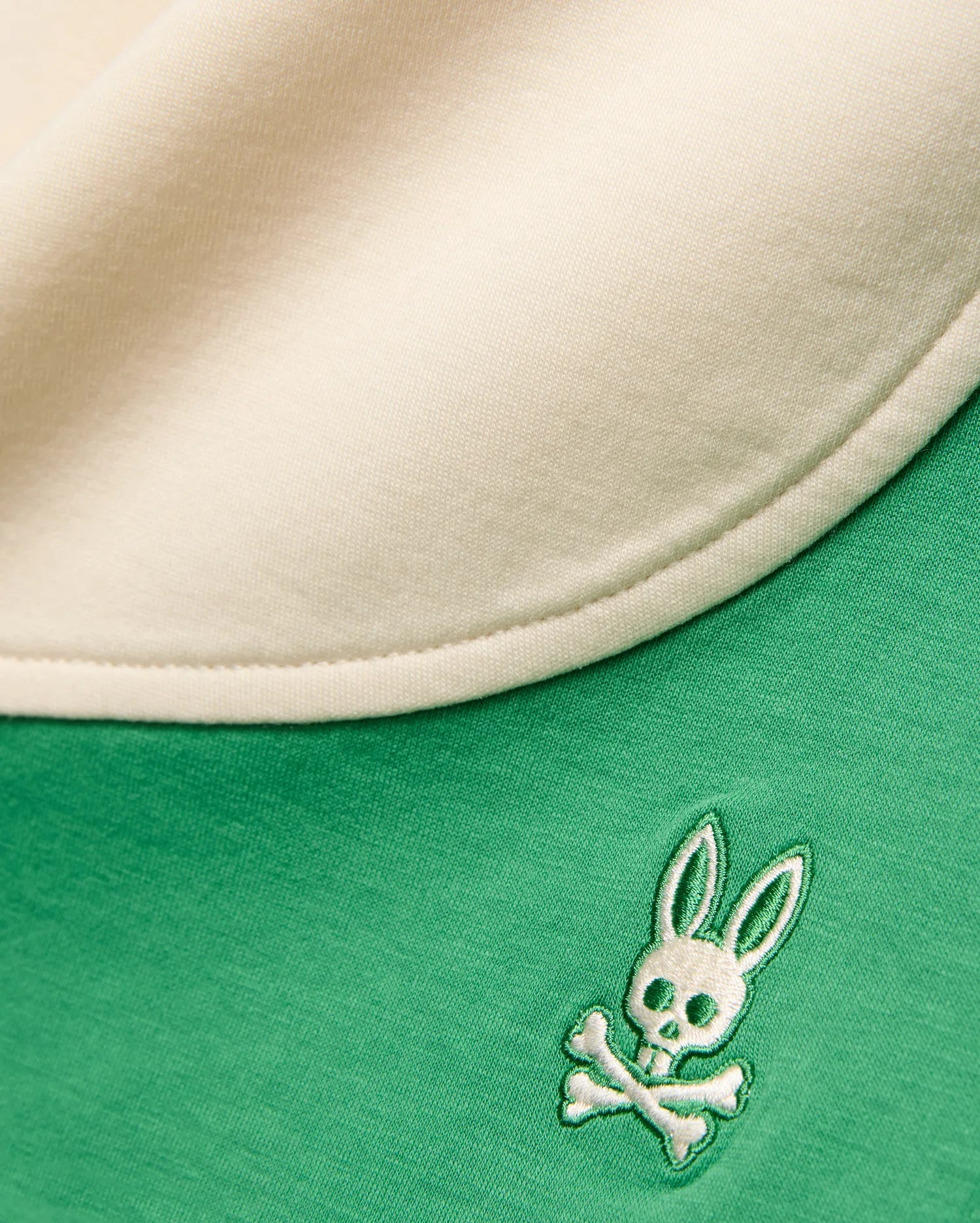 Vibrant green Kids Kelly Short in soft jersey knit, featuring a cream contrasting trim and a small, intricately embroidered white and green Psycho Bunny skull and crossbones logo.