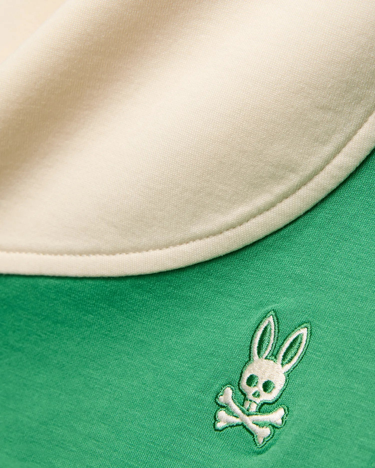 Vibrant green Kids Kelly Short in soft jersey knit, featuring a cream contrasting trim and a small, intricately embroidered white and green Psycho Bunny skull and crossbones logo.