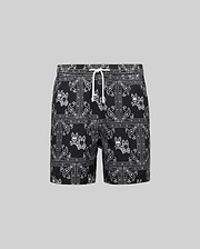 Kids Luke Swim Trunk, black classic fit swim trunks with an all-over white bandana paisley pattern featuring repeated Psycho Bunny skull logos and a white drawstring.