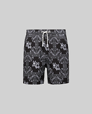 Kids Luke Swim Trunk, black classic fit swim trunks with an all-over white bandana paisley pattern featuring repeated Psycho Bunny skull logos and a white drawstring.