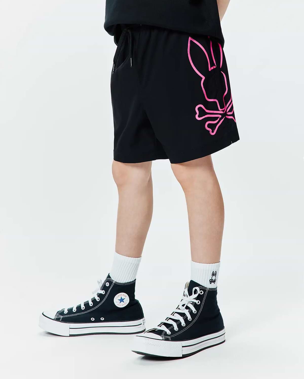 Kids Duncan Bunny Print Swim Trunk in black, featuring a large neon pink graphic Psycho Bunny skull logo on the left leg, with a relaxed fit and smooth swim fabric.