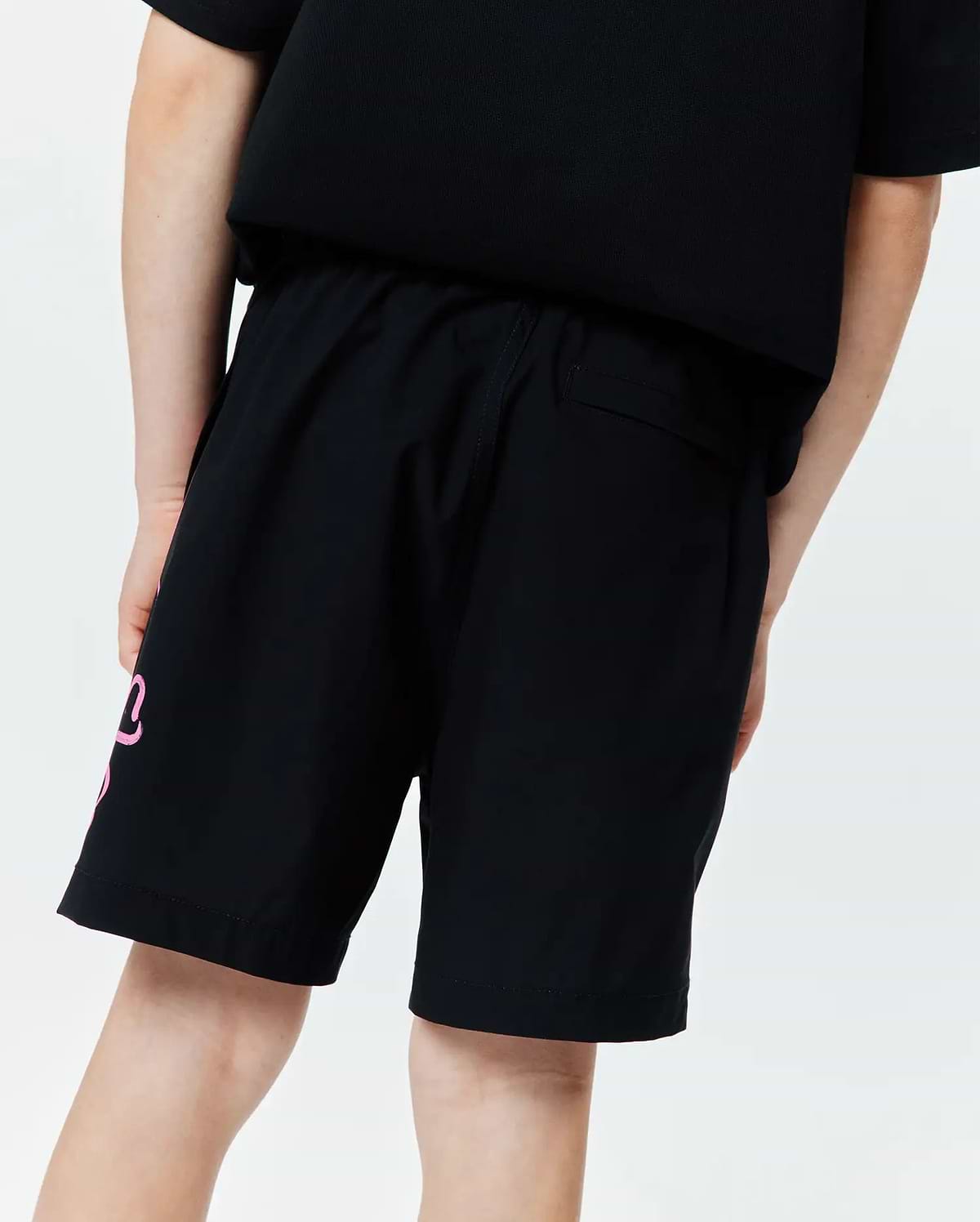 Kids Duncan Bunny Print Swim Trunk, black, featuring a large pink stylized bunny graphic on the left leg, a relaxed fit, and smooth quick-dry swim fabric.