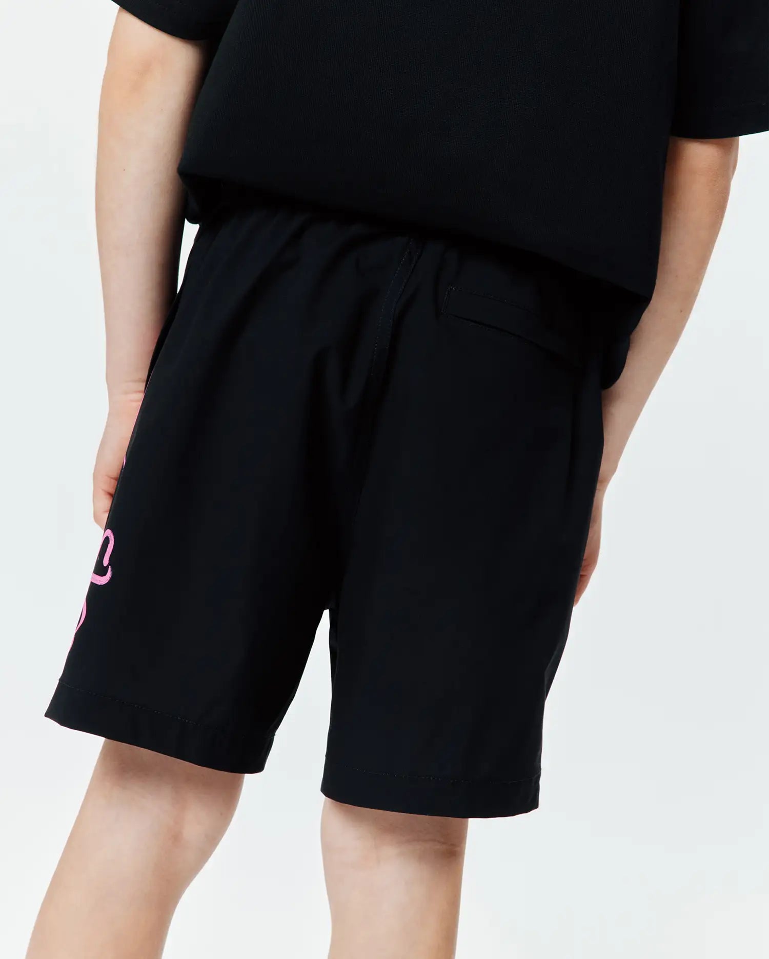 Kids Duncan Bunny Print Swim Trunk, black, featuring a large pink stylized bunny graphic on the left leg, a relaxed fit, and smooth quick-dry swim fabric.