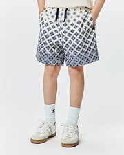 Kids Tobias Swim Trunk, cream with a navy blue all-over geometric pattern of the iconic Psycho Bunny skull logo, relaxed fit, smooth quick-dry fabric, and a navy drawstring.