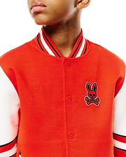 Kids Joey Knit Bomber, a vibrant orange jersey knit jacket with white sleeves, classic fit, featuring a large embroidered red and black Psycho Bunny skull logo on the left chest, and striped ribbed collar and cuffs.