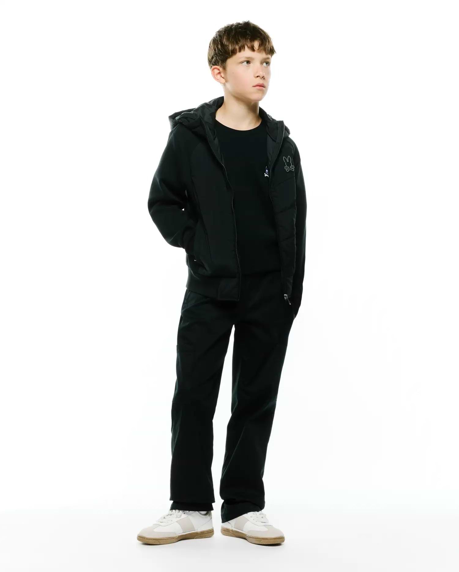 Black Kids Gordley Mix Media Jacket, a regular fit hooded full-zip jacket with smooth body and jersey sleeves, featuring a small embroidered white Psycho Bunny skull logo on the left chest.
