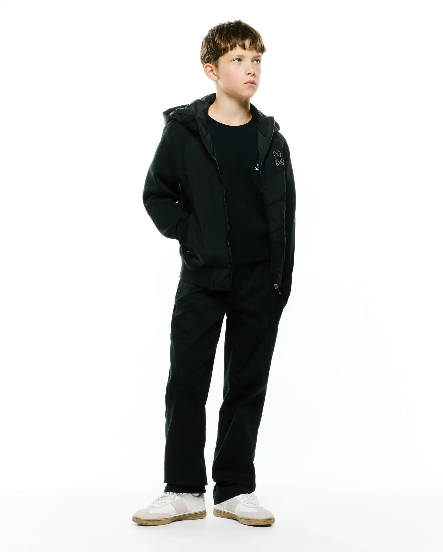 Black Kids Gordley Mix Media Jacket, a regular fit hooded full-zip jacket with smooth body and jersey sleeves, featuring a small embroidered white Psycho Bunny skull logo on the left chest.