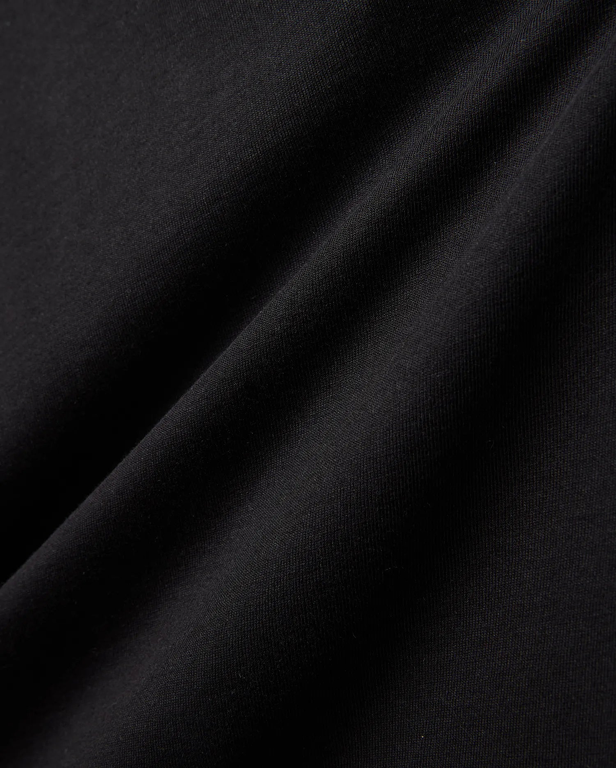 Kids Gordley Mix Media Jacket, a premium Psycho Bunny piece in deep black, showcasing a luxurious, soft-touch jersey knit fabric with subtle texture and elegant draping folds, hinting at refined streetwear style.