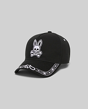 Black Kids Luke Trucker Cap with a large white embroidered Psycho Bunny skull logo on the front and a white embroidered bandana pattern along the brim.