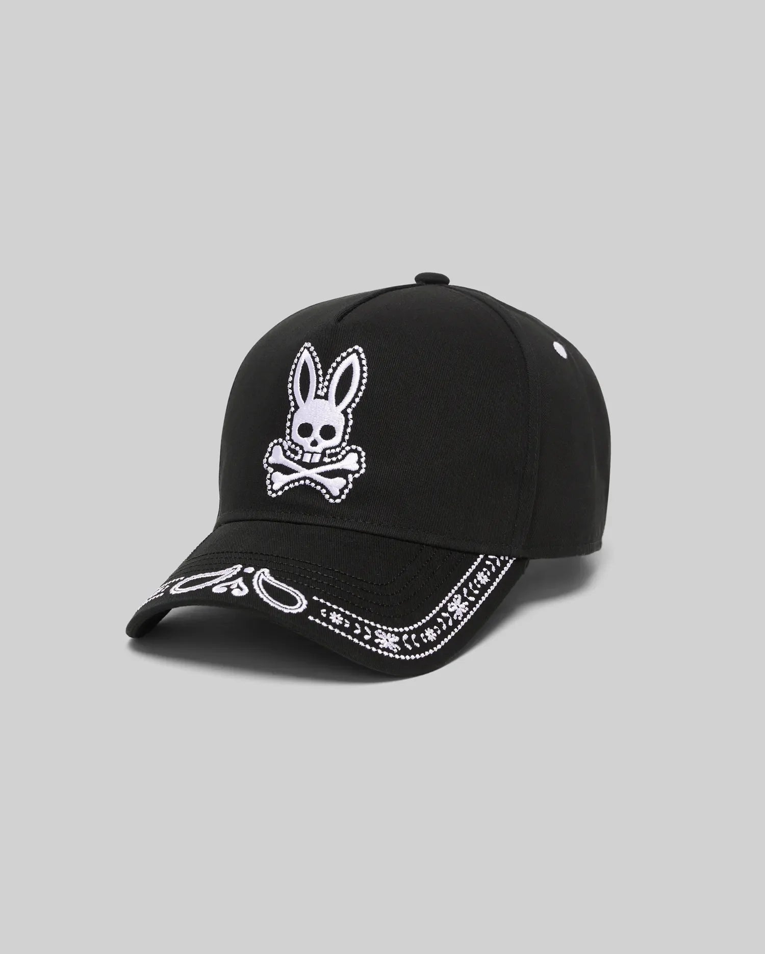 Black Kids Luke Trucker Cap with a large white embroidered Psycho Bunny skull logo on the front and a white embroidered bandana pattern along the brim.