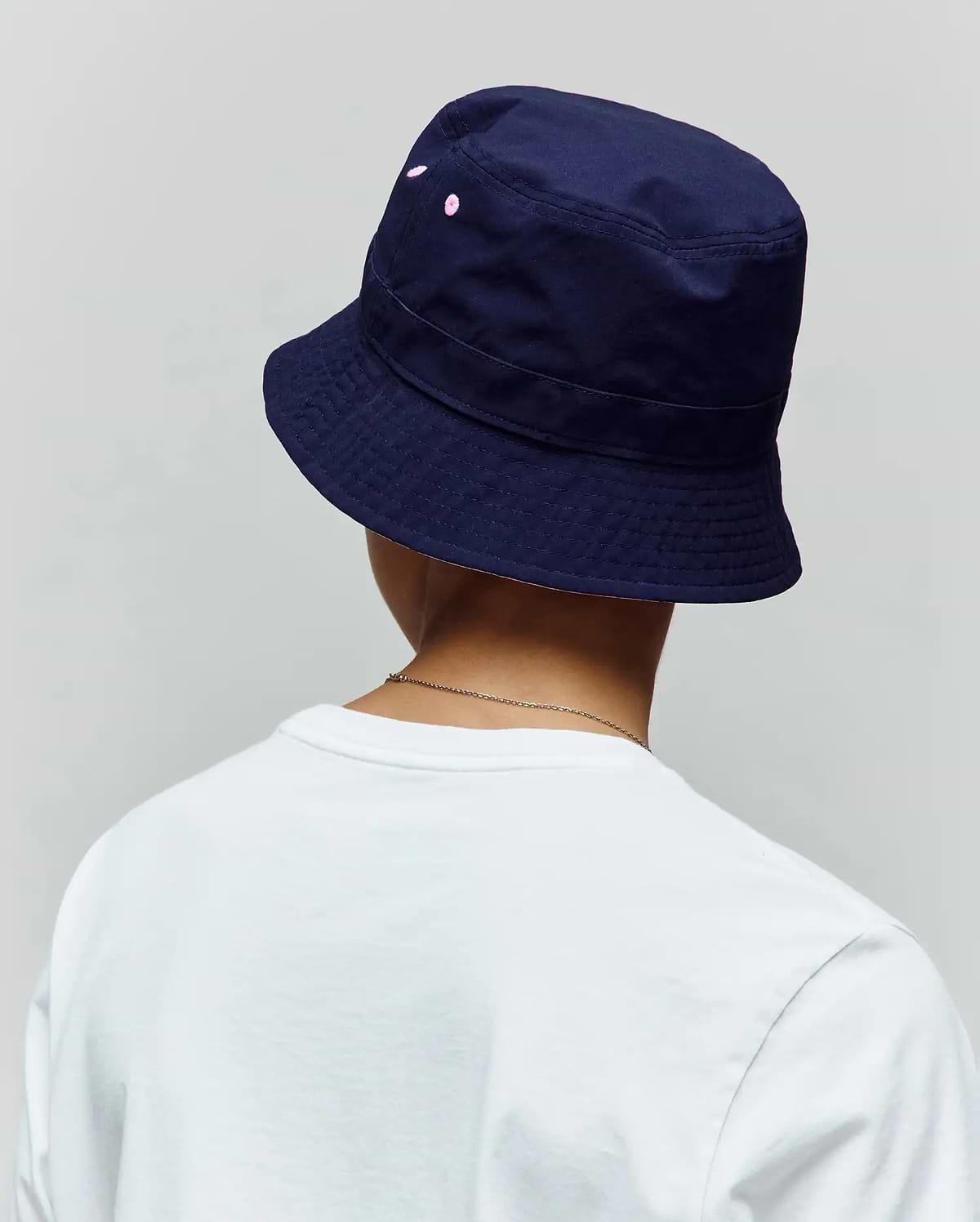 Kids Luke Reversible Bucket Hat in deep navy cotton twill, showcasing subtle pink embroidered Psycho Bunny skull dots on the side, with a classic structured brim.
