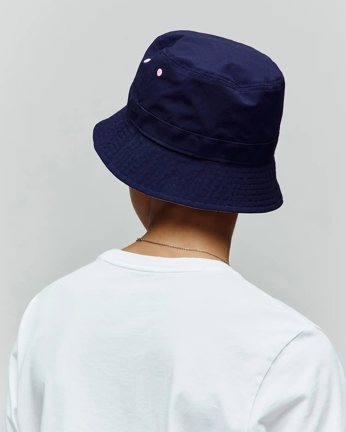 Kids Luke Reversible Bucket Hat in deep navy cotton twill, showcasing subtle pink embroidered Psycho Bunny skull dots on the side, with a classic structured brim.