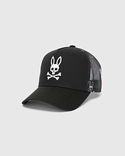 Kids Quintin Trucker Cap in black twill with a large white Psycho Bunny skull logo on the front. Features multicolor patterned mesh side and back panels with subtle bunny graphics.