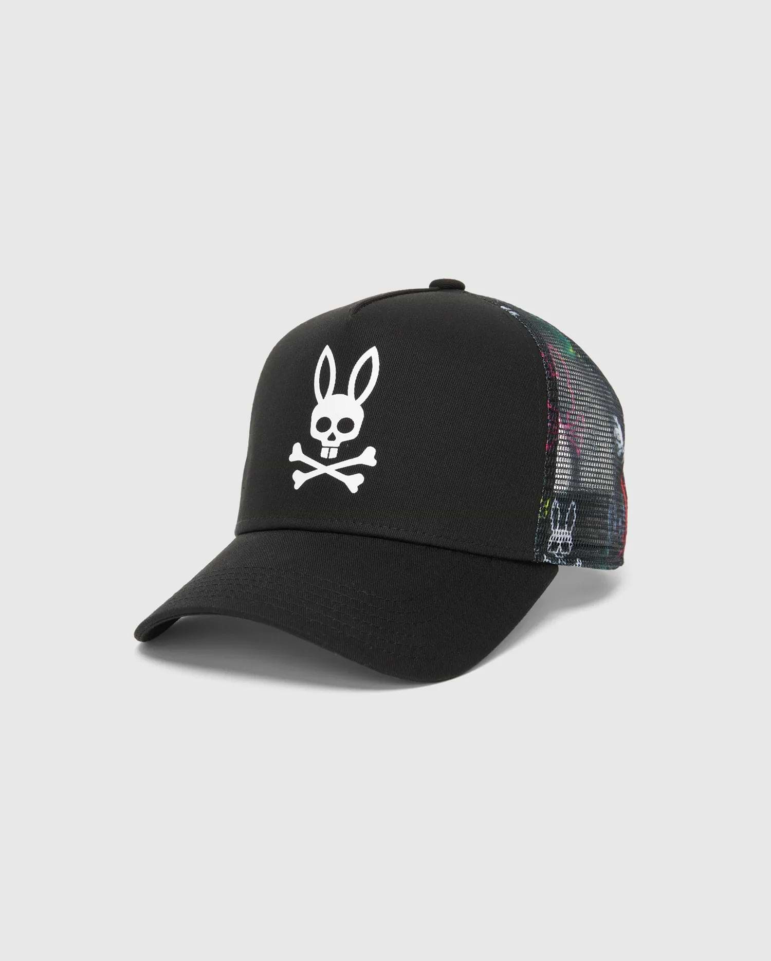 Kids Quintin Trucker Cap in black twill with a large white Psycho Bunny skull logo on the front. Features multicolor patterned mesh side and back panels with subtle bunny graphics.