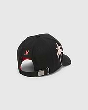 Black Kids Brad Trucker Cap with a red under brim, featuring a pink and white embroidered palm tree, a small red embroidered bunny skull on the back, and a metal buckle with an engraved bunny skull.