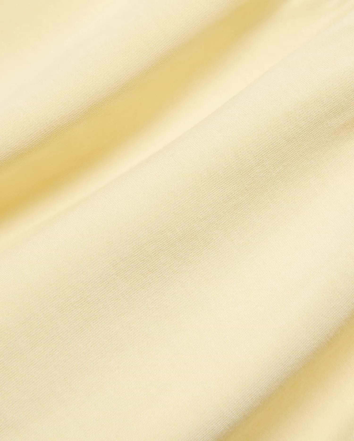 Kids Girl's Penelope Dress, crafted from premium soft pale yellow jersey knit fabric, showcasing its subtle texture, elegant draping, and refined Psycho Bunny quality. (6)