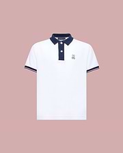The Psycho Bunny KIDS ARCHIVE CLASSIC BUNNY PIQUE POLO (KT0100010) is a white, short-sleeve Pima cotton shirt with a navy collar and trim, three dark buttons, and an embroidered Bunny logo on the left chest, shown on a pale pink background.