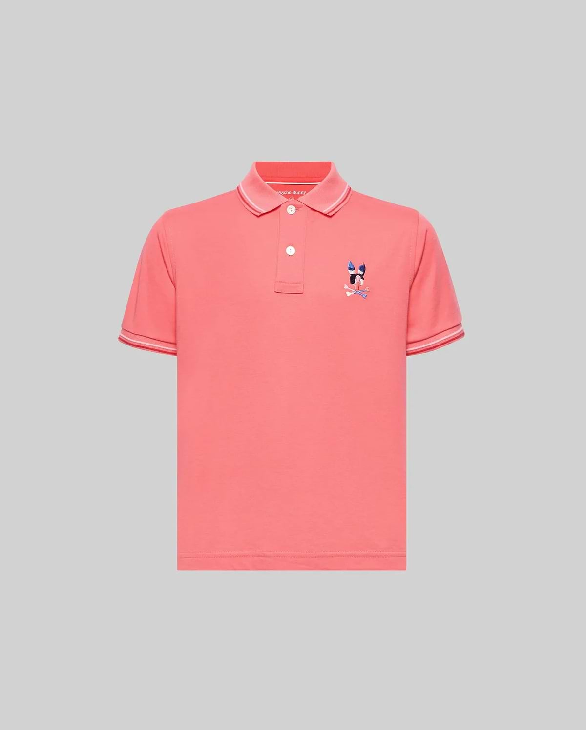 Kids Ara Pique Polo in coral pink, featuring a classic fit, pique knit fabric, white two-button placket, ribbed collar and cuffs with white tipping, and a small embroidered multi-color Psycho Bunny skull logo on the left chest.