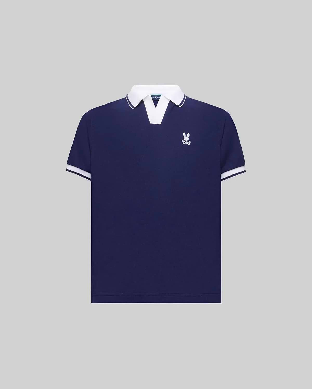 Kids Christiano Pique Polo in navy blue with a classic fit, featuring a white V-neck collar, white striped cuffs, and a small embroidered white Psycho Bunny skull logo on the left chest.