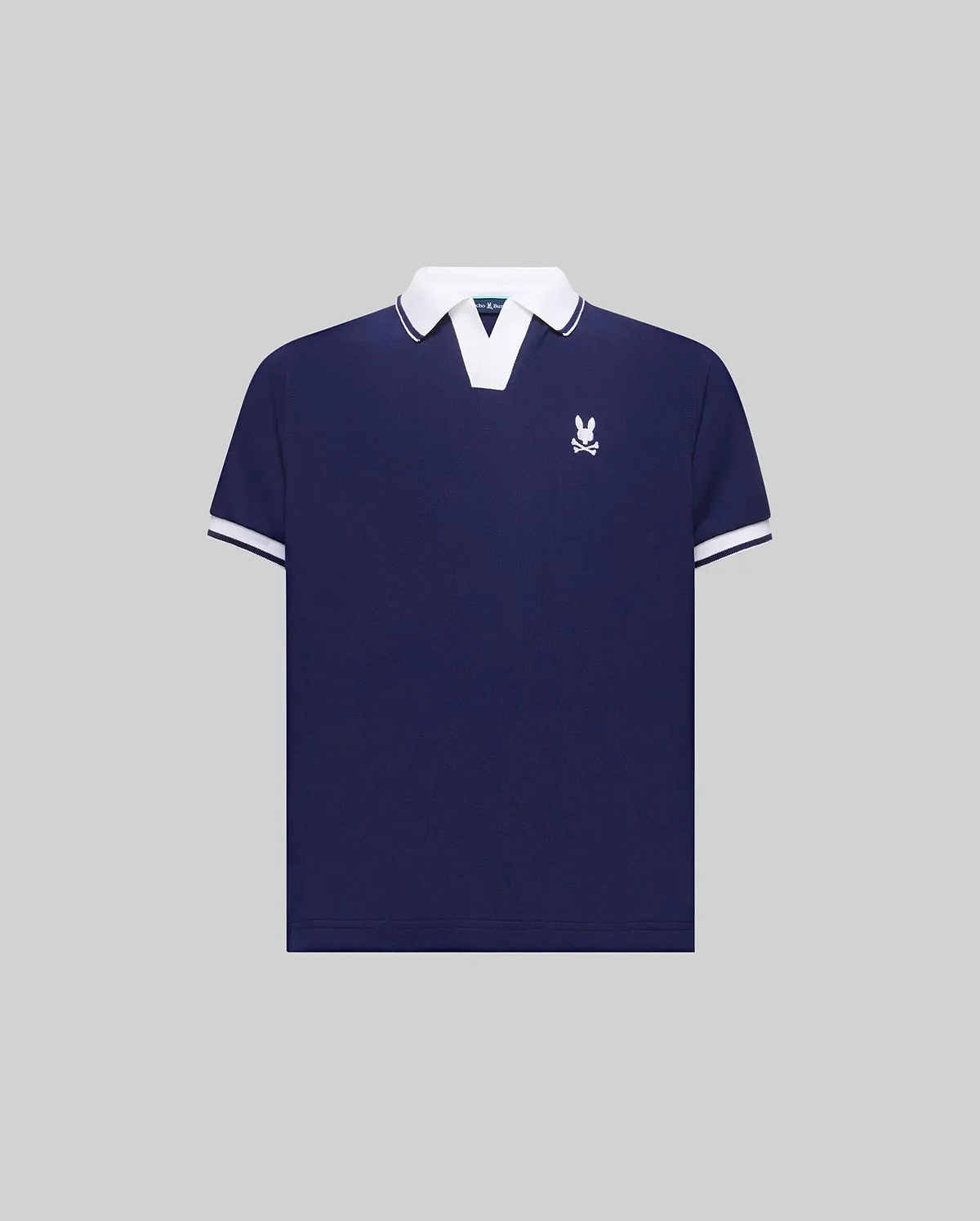 Kids Christiano Pique Polo in navy blue with a classic fit, featuring a white V-neck collar, white striped cuffs, and a small embroidered white Psycho Bunny skull logo on the left chest.