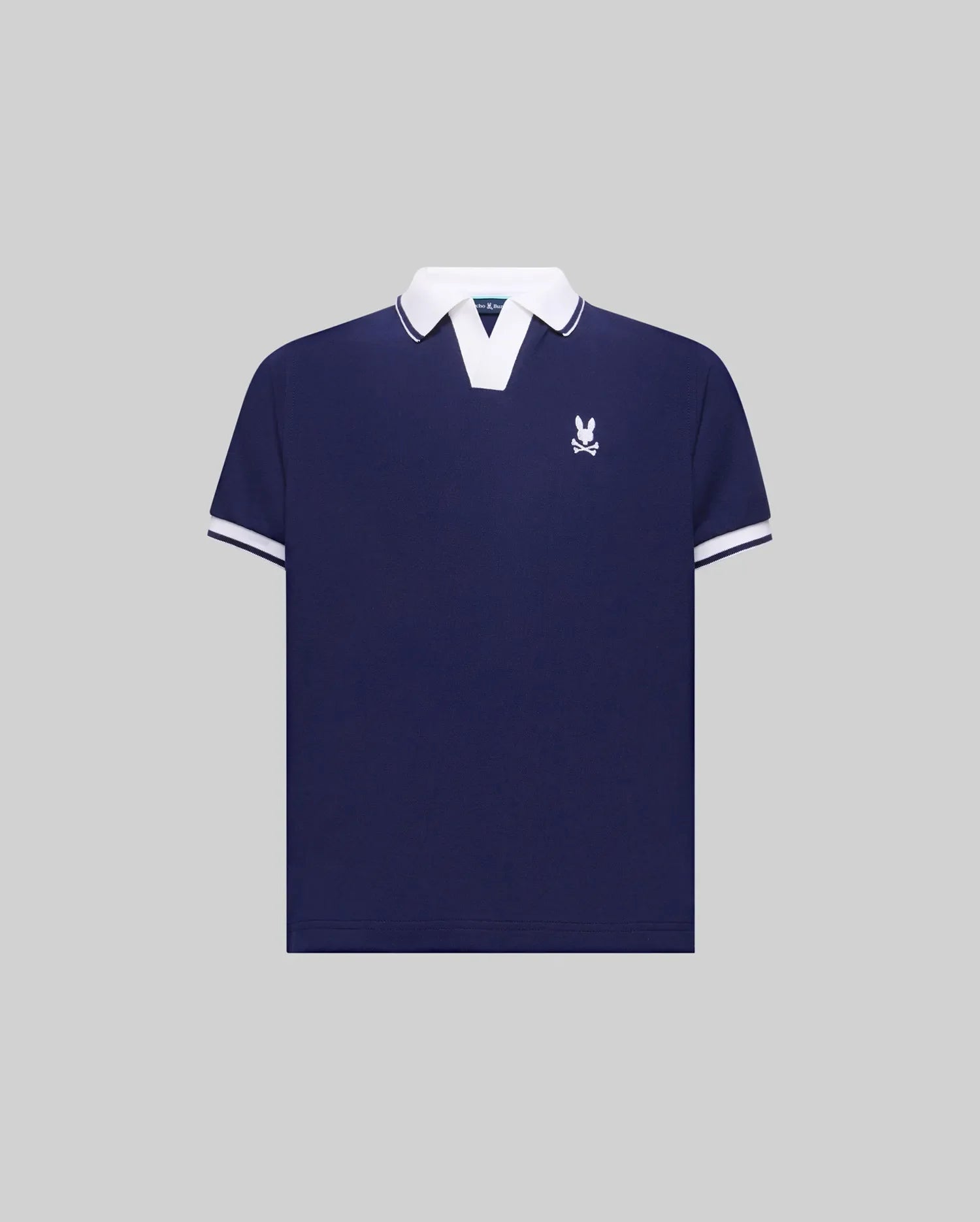 Kids Christiano Pique Polo in navy blue with a classic fit, featuring a white V-neck collar, white striped cuffs, and a small embroidered white Psycho Bunny skull logo on the left chest.