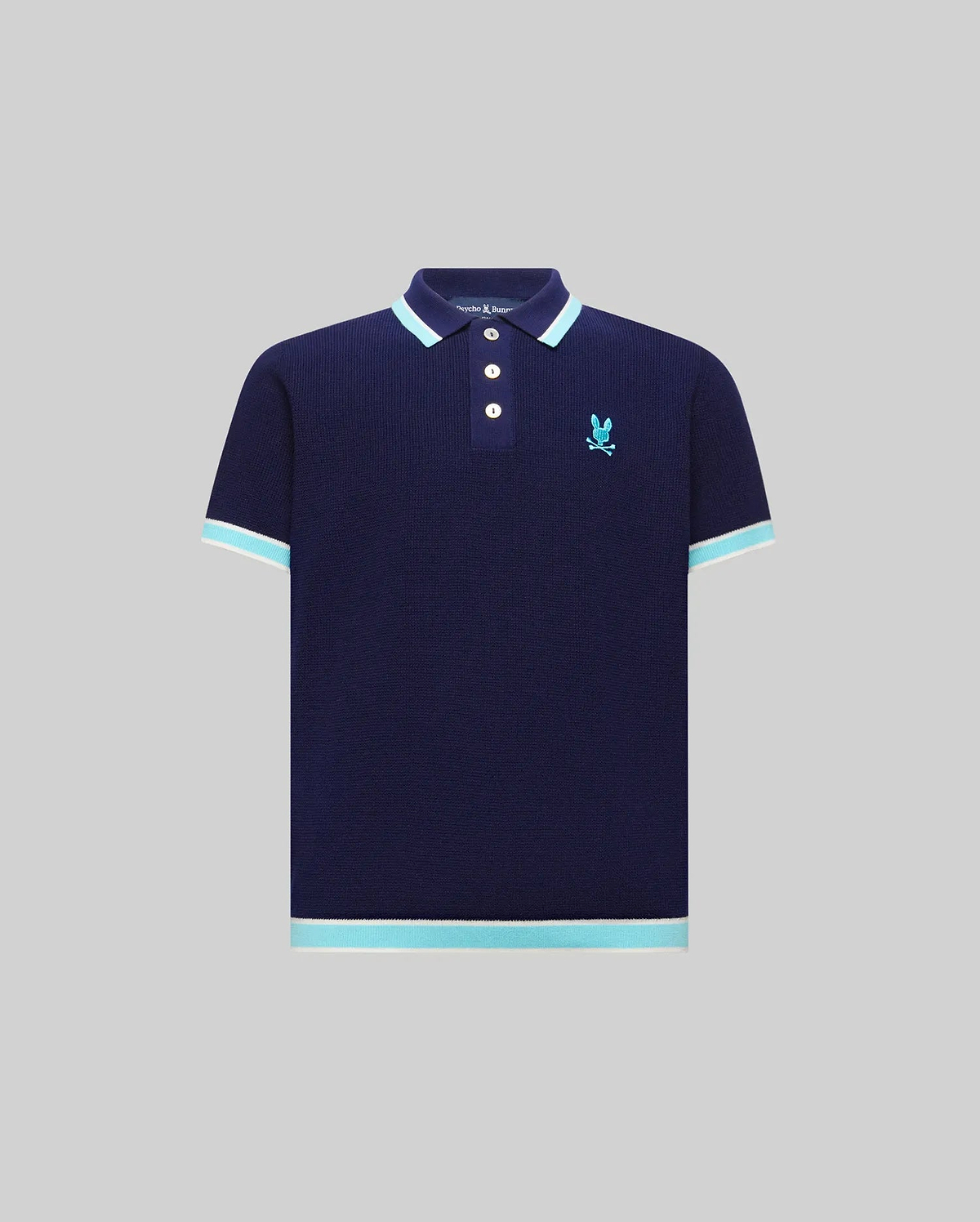 Kids Dax Knit Polo in navy, featuring a classic fit, knit texture, and a small embroidered light blue Psycho Bunny skull logo on the left chest. It has light blue and white striped collar, cuffs, and hem.