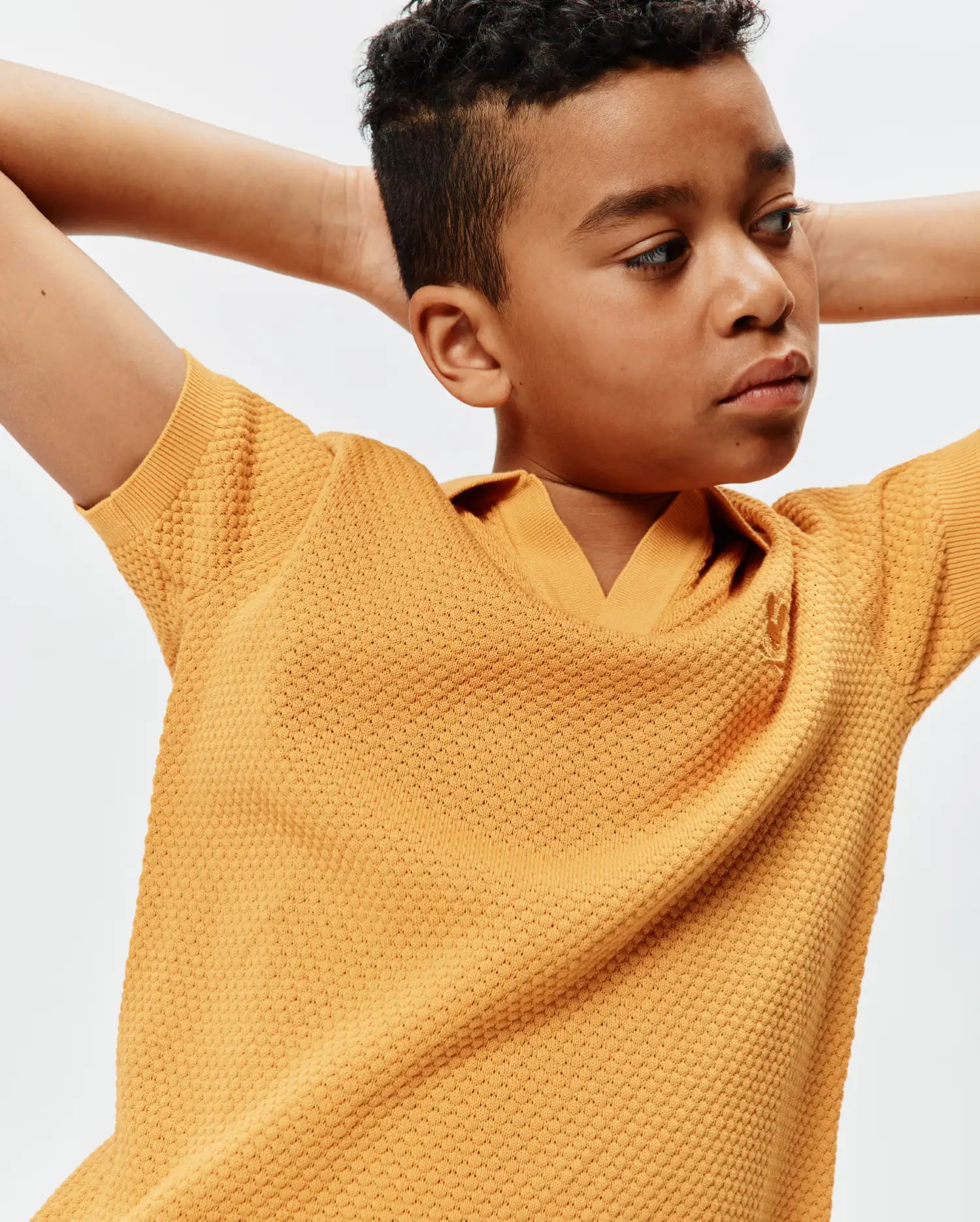 Kids Devon Knit Polo in vibrant mustard yellow, with a distinctive textured knit, classic fit, and a small embroidered Psycho Bunny skull logo on the left chest.