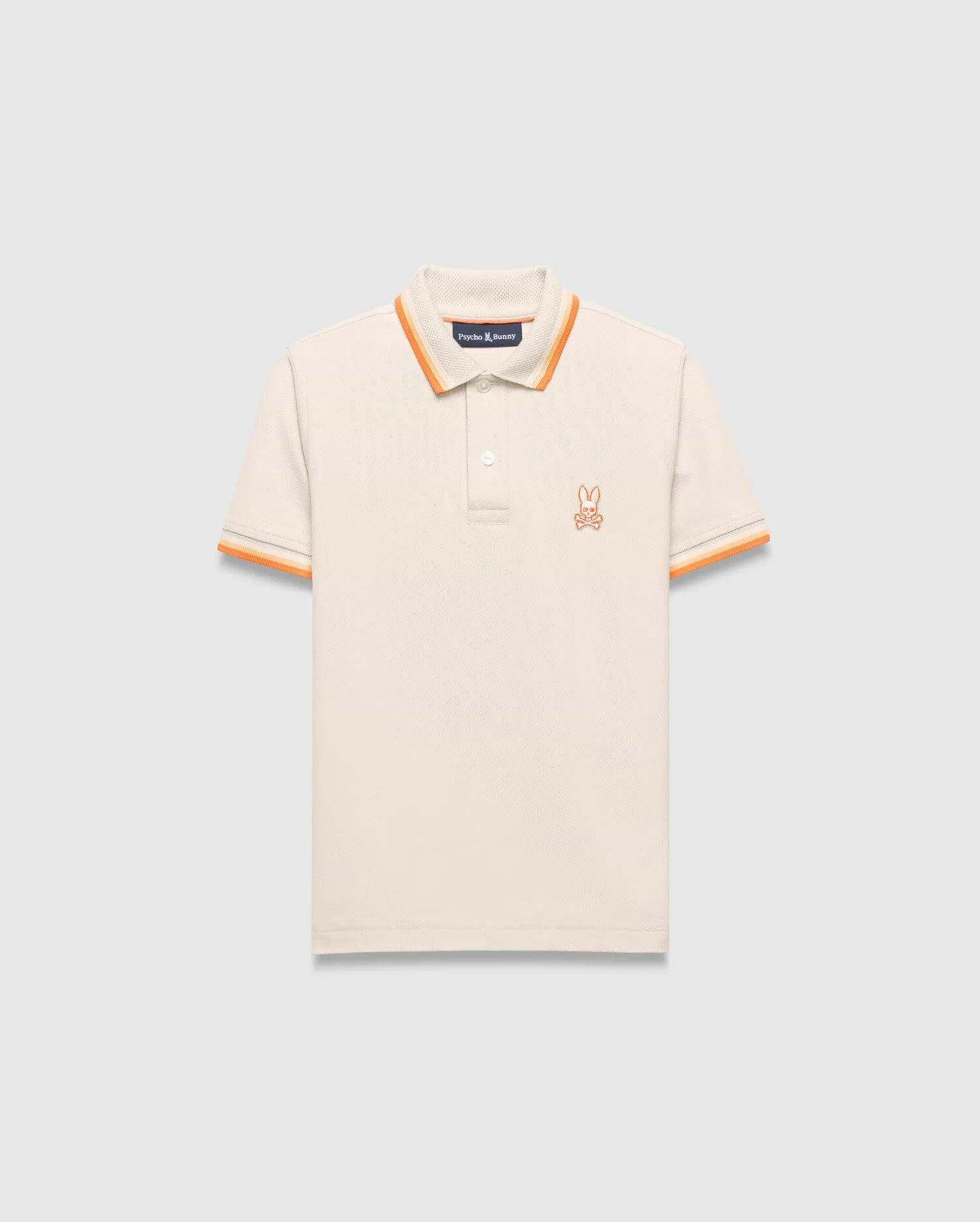 Kids Holden Pique Polo, cream classic fit pique polo with orange striped collar and cuffs, featuring a small embroidered orange Psycho Bunny skull logo on the left chest.