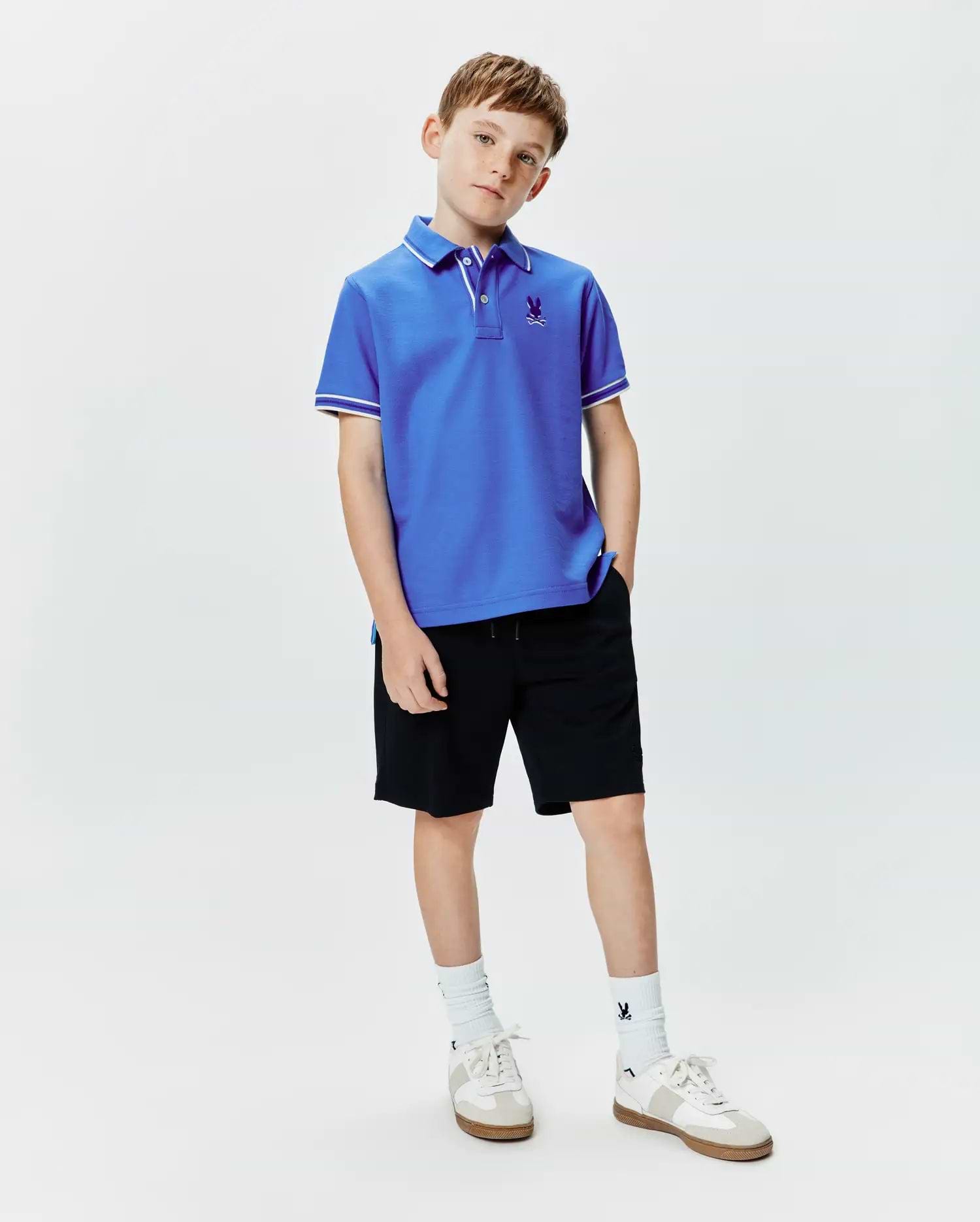 Kids Brad Pique Polo in royal blue, featuring a classic fit, pique knit fabric, white tipping on the collar and sleeve cuffs, and a small embroidered Psycho Bunny skull logo on the left chest.