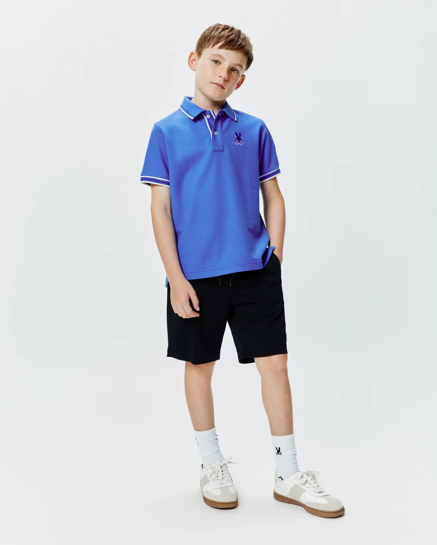 Kids Brad Pique Polo in royal blue, featuring a classic fit, pique knit fabric, white tipping on the collar and sleeve cuffs, and a small embroidered Psycho Bunny skull logo on the left chest.