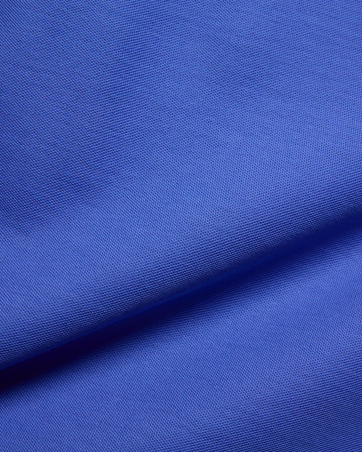 Kids Brad Pique Polo, a vibrant royal blue premium pique fabric, showcasing its distinctive textured weave, embodying Psycho Bunny's bold, refined streetwear aesthetic for a classic fit.
