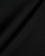 Black Kids Brad Pique Polo fabric, a close-up revealing the refined, breathable textured pique weave with subtle, elegant folds, perfect for premium Psycho Bunny menswear.
