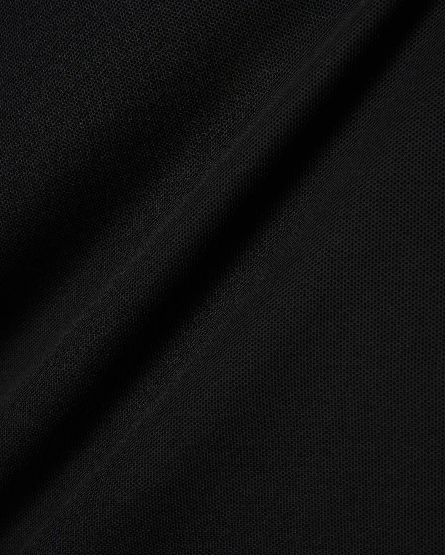 Black Kids Brad Pique Polo fabric, a close-up revealing the refined, breathable textured pique weave with subtle, elegant folds, perfect for premium Psycho Bunny menswear.