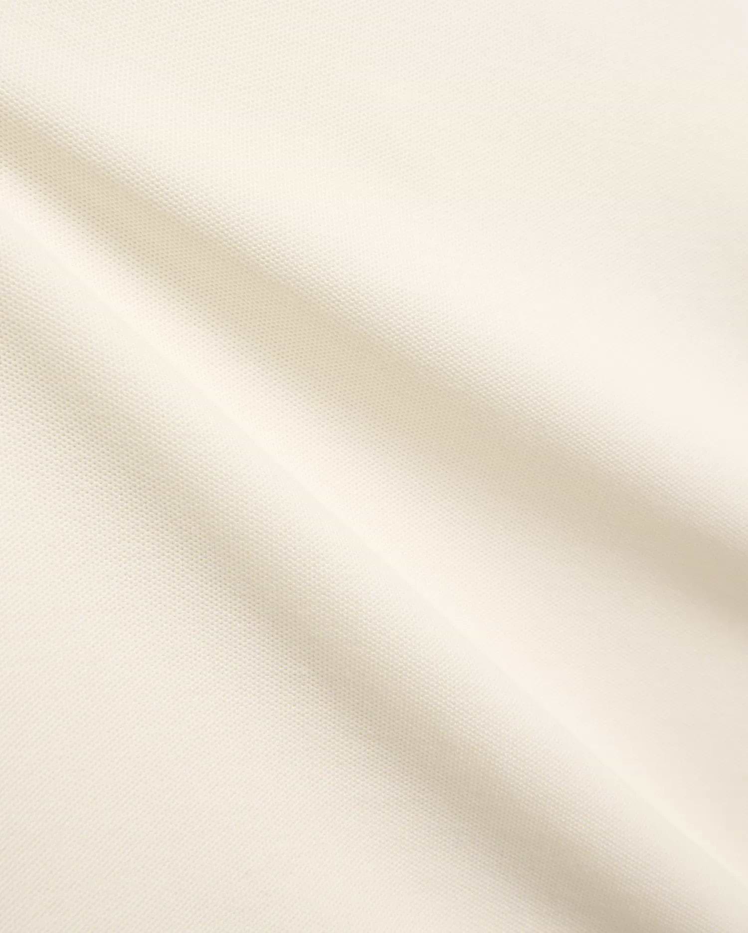 Kids Sunny Pique Polo, a creamy off-white shirt crafted from textured pique fabric, featuring the signature small embroidered Psycho Bunny skull logo on the left chest. (6)