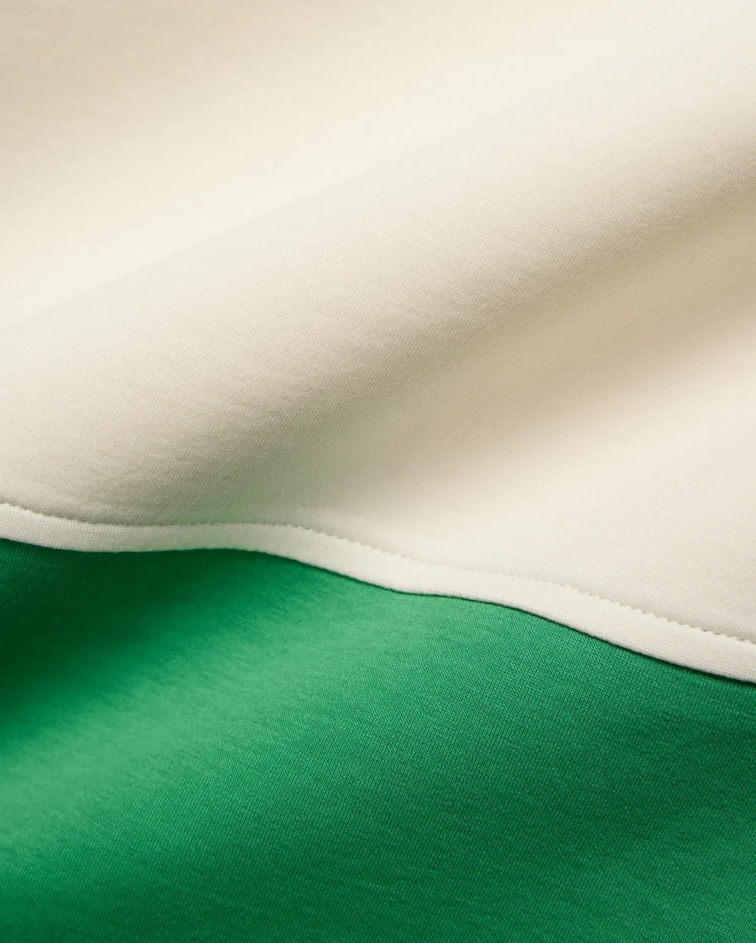 Kids Kelly Oversized Polo in soft jersey knit, featuring a bold color-block design with vibrant kelly green and creamy off-white panels joined by a neat seam.